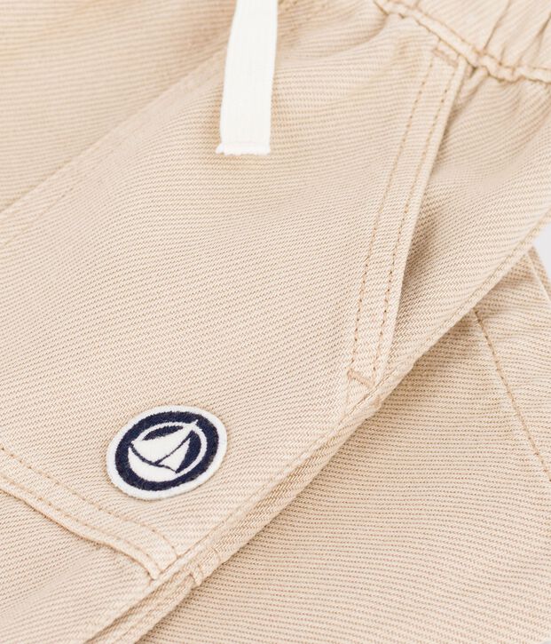 Babies' cargo-style trousers in plain cotton with a badge beige