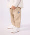 Babies' cargo-style trousers in plain cotton with a badge beige