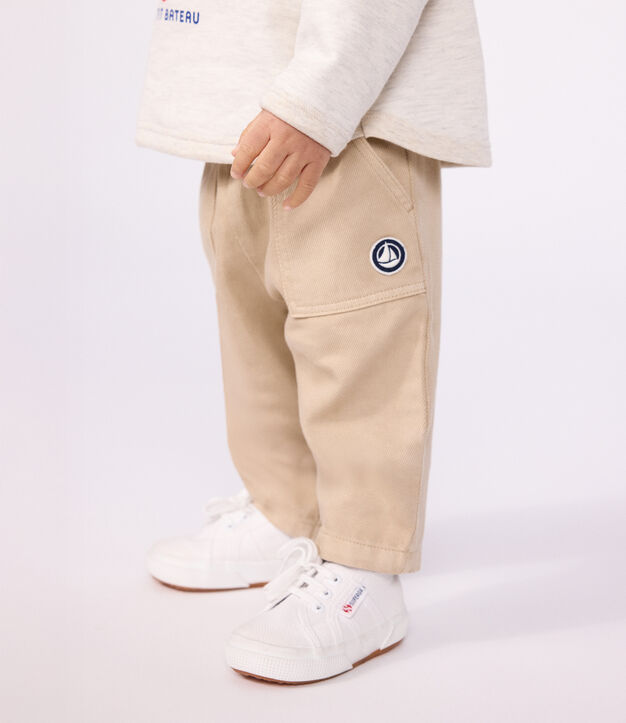 Babies' cargo-style trousers in plain cotton with a badge beige