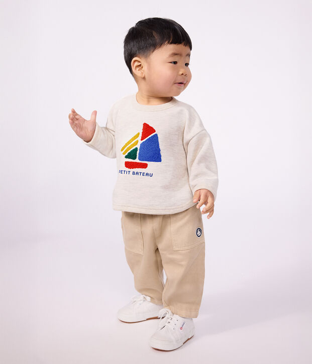 Babies' cargo-style trousers in plain cotton with a badge beige